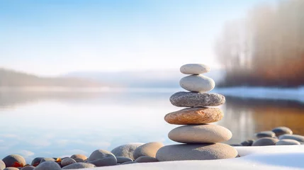 Tuinposter Pebbles or stones balanced on snowy ground. Concept of harmony, meditation, and wellness in winter. © Ameer