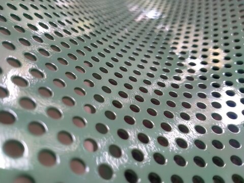 Perforated pattern on white colored iron plate	