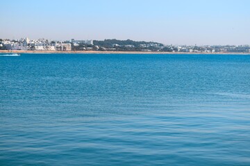 Fototapeta na wymiar Panorama landscape view of blue sea water with city buildings