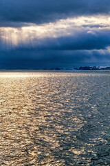 Sun sparkling water with sun rays from the storm clouds