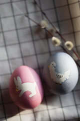 Easter serving. two colored eggs and willow branches on textile napkin