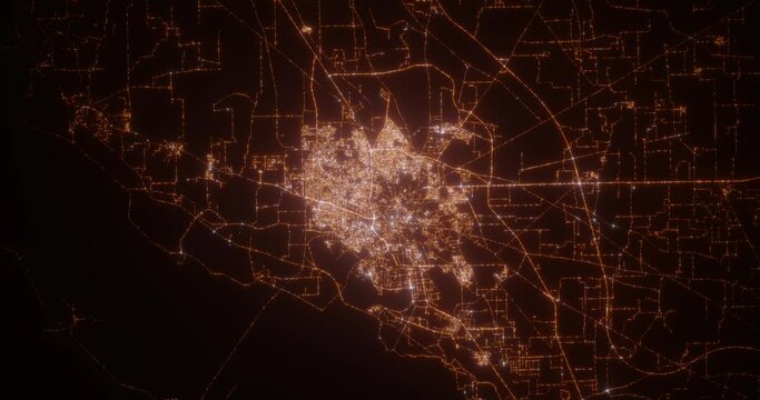 Multan (Pakistan) top view at night. Aerial view on modern city with lights. Camera is flying above the city, moving backward. Vertical video. The north is on the left side