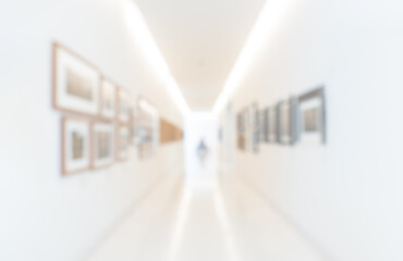 Blurred perspective photo scene of art exhibition at gallery or museum with paintings or artist works, room decoration. Abstract blur background of white clean hallway in modern hall building.