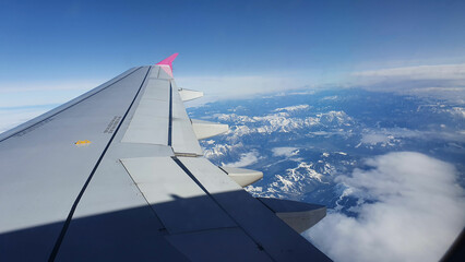 Fototapeta na wymiar view of snowy mountains and wing of airplane