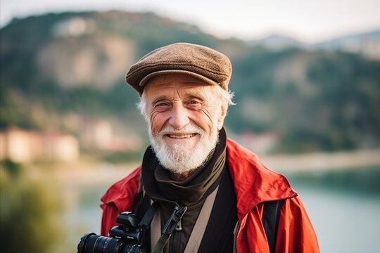 Portrait of a senior photographer with a camera on the river bank