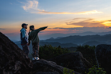 Hiker father and daughter standing at top of the mountains