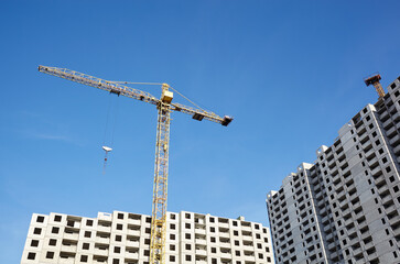 Tower crane building a house. Concrete building under construction. Construction site