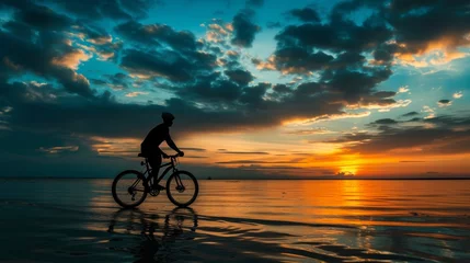 Foto op Plexiglas Sunset beach bicycling, sportsman silhouette with cloudy horizon © Lucija