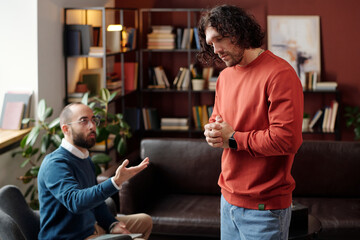 Selective focus of young Caucasian man suffering anxiety disorder or PTSD having psychotherapy session