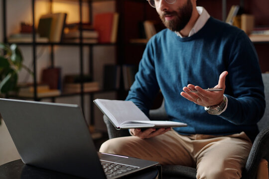 Selective focus shot of bearded psychologist having conversation with patient or colleague on video call