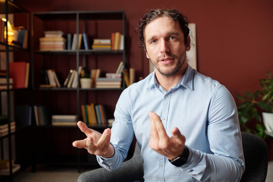 POV of Caucasian man wearing light blue shirt sitting in modern office talking on video call