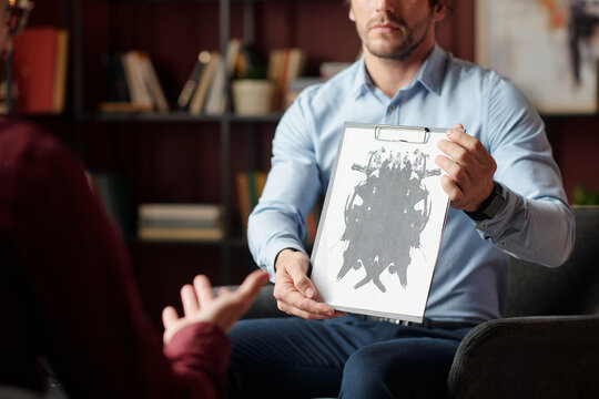 Selective focus shot of psychologist showing abstract picture to patient examining emotional state