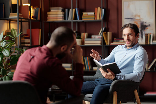 Selective focus of Caucasian psychotherapist talking to male patient suffering anxiety disorder