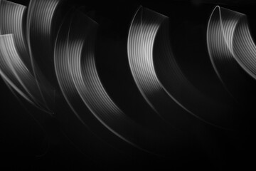 White neon flowing wave of light as trails with smooth stripes on black background, pattern....