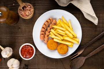 Mix Platter of Snack filled with french fries, nugget, sausage and chili sauce on wooden table