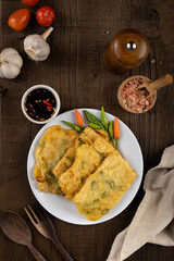 Deep fried tempeh or Tempe mendoan goreng made from soy bean with flour batter and spring onion on...