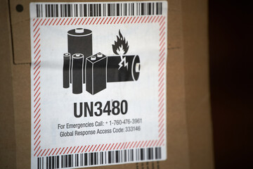 A flammable lithium battery is shipped in an envelope with a danger label. The label warns of the...