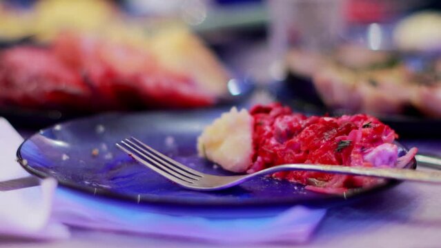 Remains of food and a fork lie in a plate on the festive table, close-up
