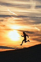 Sporty man runs down hill in silhouette - 726282928