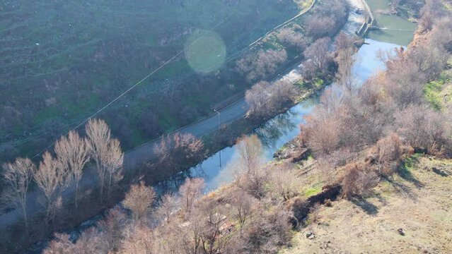 Camera moves and captures the scenic Hrazdan river and gorge from above, on a bright sunny winter day, high angle view, uhd, 4k, 3840, 2160