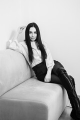 Fototapeta premium business woman with long brunette hair in white shirt and black skirt on grey background. Black and white portrait of beautiful young brunette