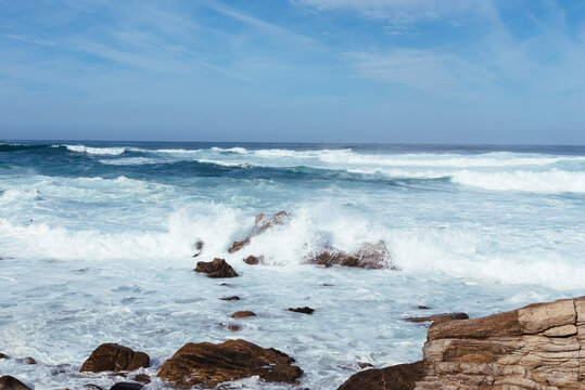 White waves hitting rocks on the ocean shore