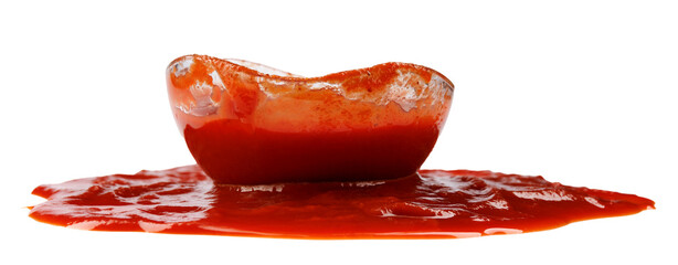 Tomato sauce . Glass cup with ketchup and a puddle of ketchup spilled around it isolated on a white...