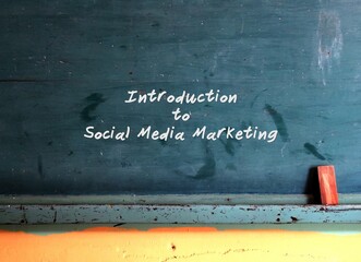 Green chalkboard with text written Introduction to Social Media Marketing , concept of the importance of learning effective using social media for business