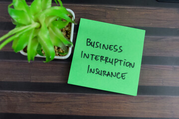 Concept of Business Interruption Insurance write on sticky notes isolated on Wooden Table.