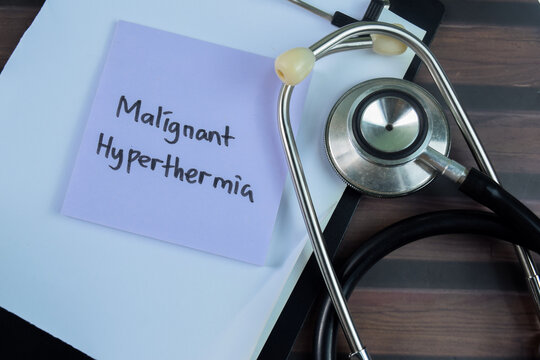 Concept of Malignant Hyperthermia write on sticky notes with stethoscope isolated on Wooden Table.