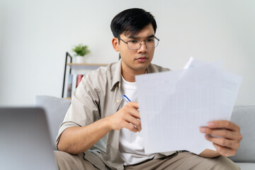 Man is calculating annual tax with calculator and filling form of Individual Income Tax Return....