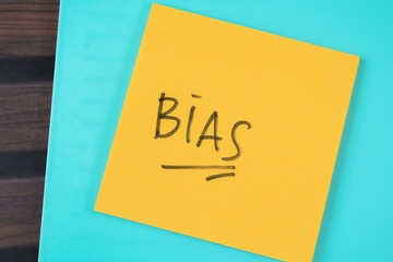 Concept of BIAS write on sticky notes isolated on Wooden Table.