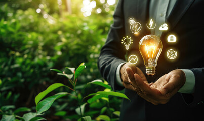 businessman holding light bulb against nature on a green background with energy source icons, sustainable development, ESG, Ecology