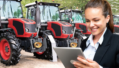 Female sales representative showcasing agricultural tractors with digital tablet. Businesswoman in...