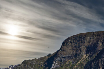 Westcap in Norway. Mountain that reaches into the fjord. Cloudy sky. Landscape shot