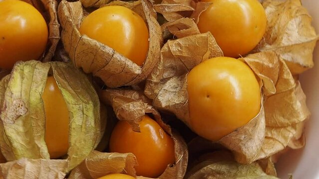 Cape gooseberry. Sweet physalis berry on wooden table, Pile of cape gooseberry in plate