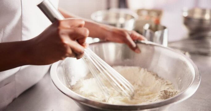 Hands, eggs or whisk flour mixture on table, chef or process of dough wheat on kitchen counter. Baker, working and wet to dry ingredients for french bread, hospitality and culinary cooking in hotel
