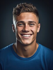 Obraz premium Young man smiling in front of a dark background.