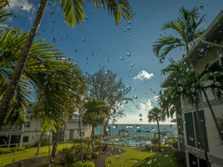 Grand Cayman, Cayman Islands, May 25th 2023, view of rain drops on a window facing the Caribbean Sea - 726351524