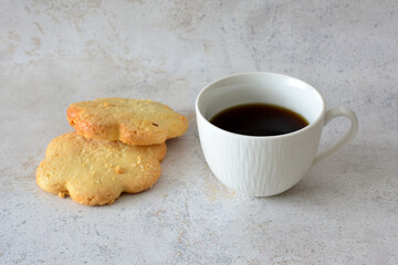 white cup with black coffee and sugr biscuits  