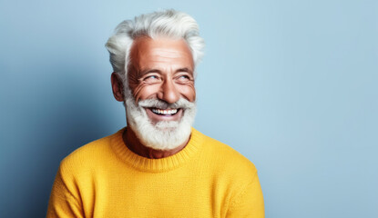 Obraz premium Joyful mature man with stylish white hair and beard, wearing a casual light sweater, radiating confidence and happiness on a light background