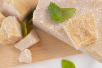 Slices of parmesan cheese, close-up. grano padano cheese with fresh green basil leaves