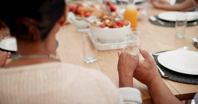 Family, praying and holding hands at lunch in home with thanksgiving, gratitude or food at table. People, men and women at brunch for celebration, party or connection with religion, faith and worship