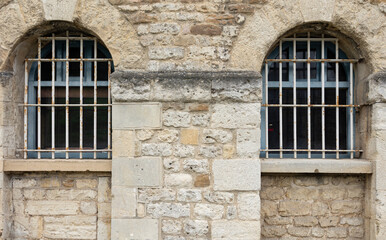 Fototapeta na wymiar Outside of victorian prison with bars at the windows