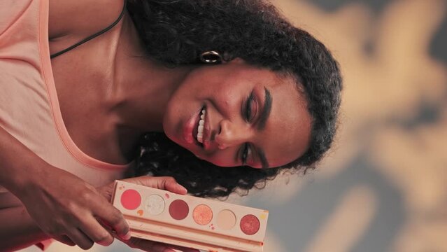 Young attractive model showing a set of cosmetics