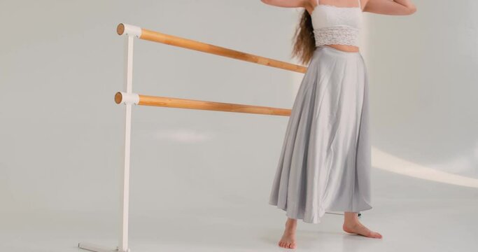 Young girl strtching her leg,holding barrer,raising arm, jumping at studio.woman gymnast ballerina dancing indoors. Girl doing acrobatic figures string.girl repare for performance. slow motion