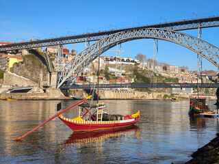 Tranquilidade sobre o rio: Barco Rabelo no Rio Douro na Ribeira de Vila Nova de Gaia, com a Ponte metálica Dom Luís I e a velha cidade como pano de fundo