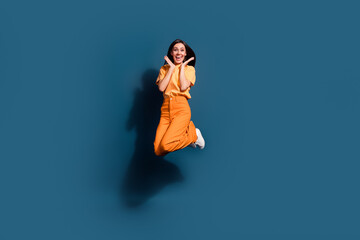 Full length photo of amazed lady wear orange t shirt and yellow pants touch cheeks jumping in shock isolated on dark blue color background - obrazy, fototapety, plakaty