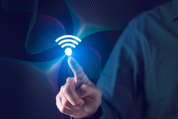 Businessman hand pointing WiFi symbol with digital information waves. Digital connectivity and...