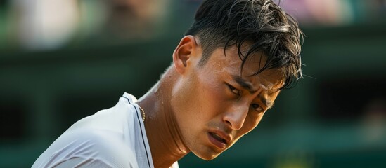 An Asian male tennis player, looking disappointed and upset after losing a match, reflecting on his failure.